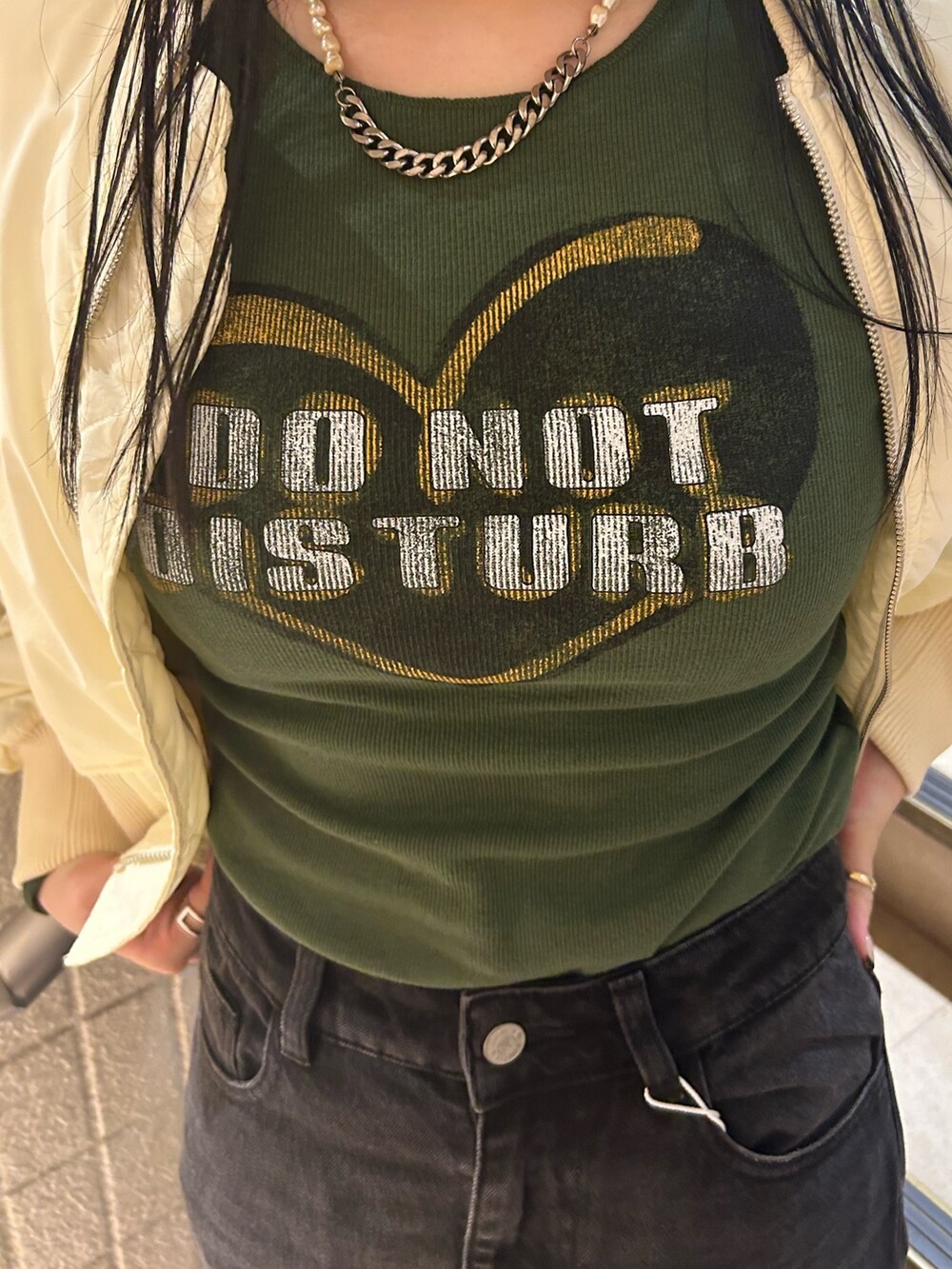 ベージュ系のブーツ、ブラック系のデニムパンツ、ホワイト系のMA-1を着用したレディースの秋コーディネートの6枚目の写真