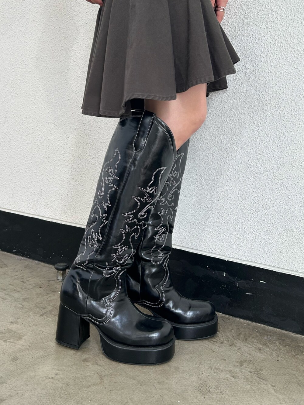 ブラック系のブーツ、ブラック系のスカート、ブラック系のニット/セーターを着用したレディースの冬コーディネートの8枚目の写真