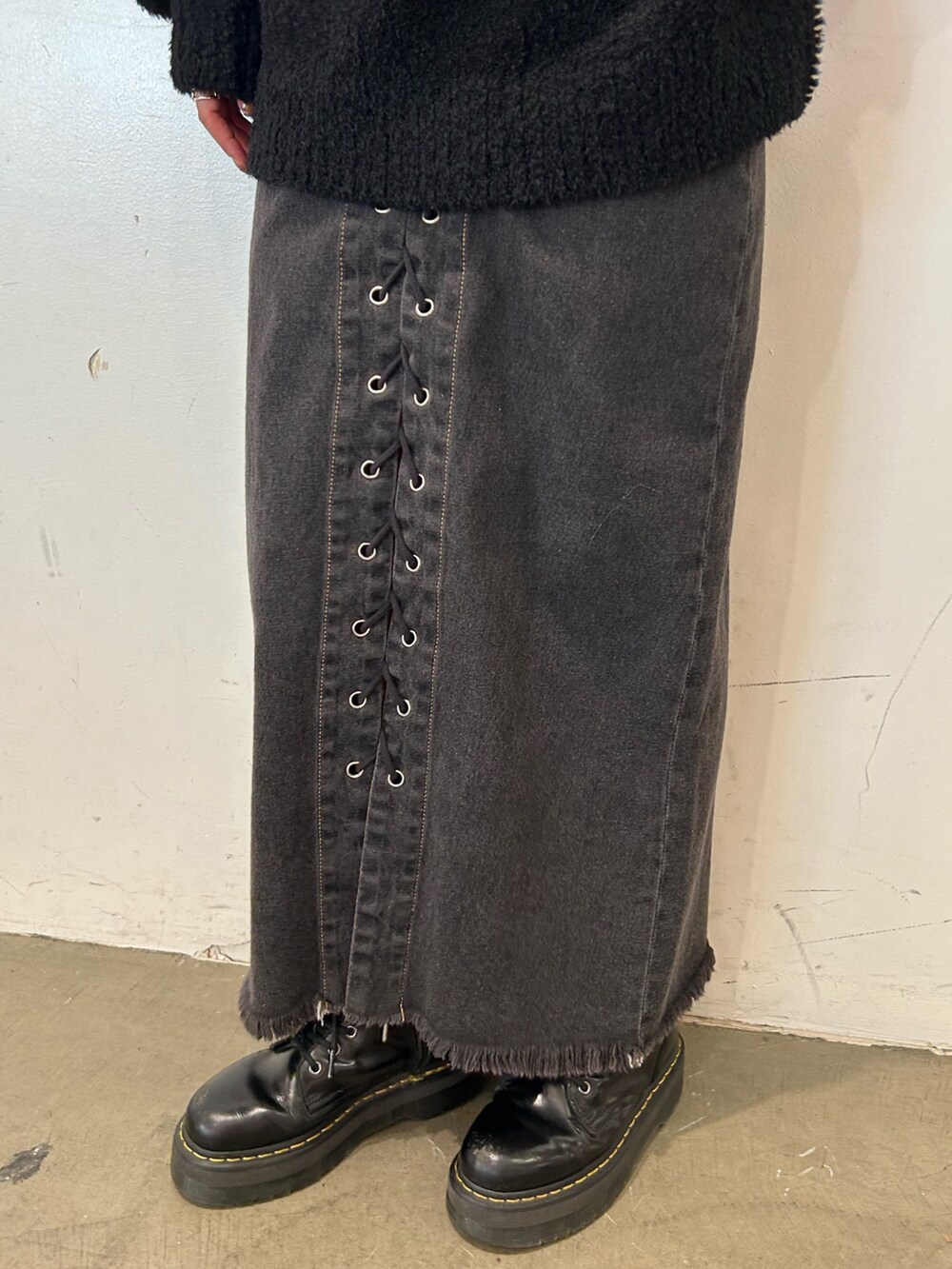ブラック系のデニムパンツ、ブラック系のブーツ、ブラック系のニット/セーターを着用したレディースの秋コーディネートの6枚目の写真
