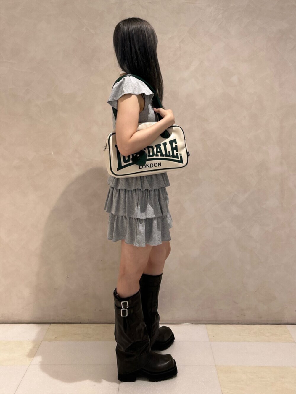 ブラック系のブーツ、グレー系のワンピース、ホワイト系のボストンバッグを着用したレディースの秋コーディネートの2枚目の写真