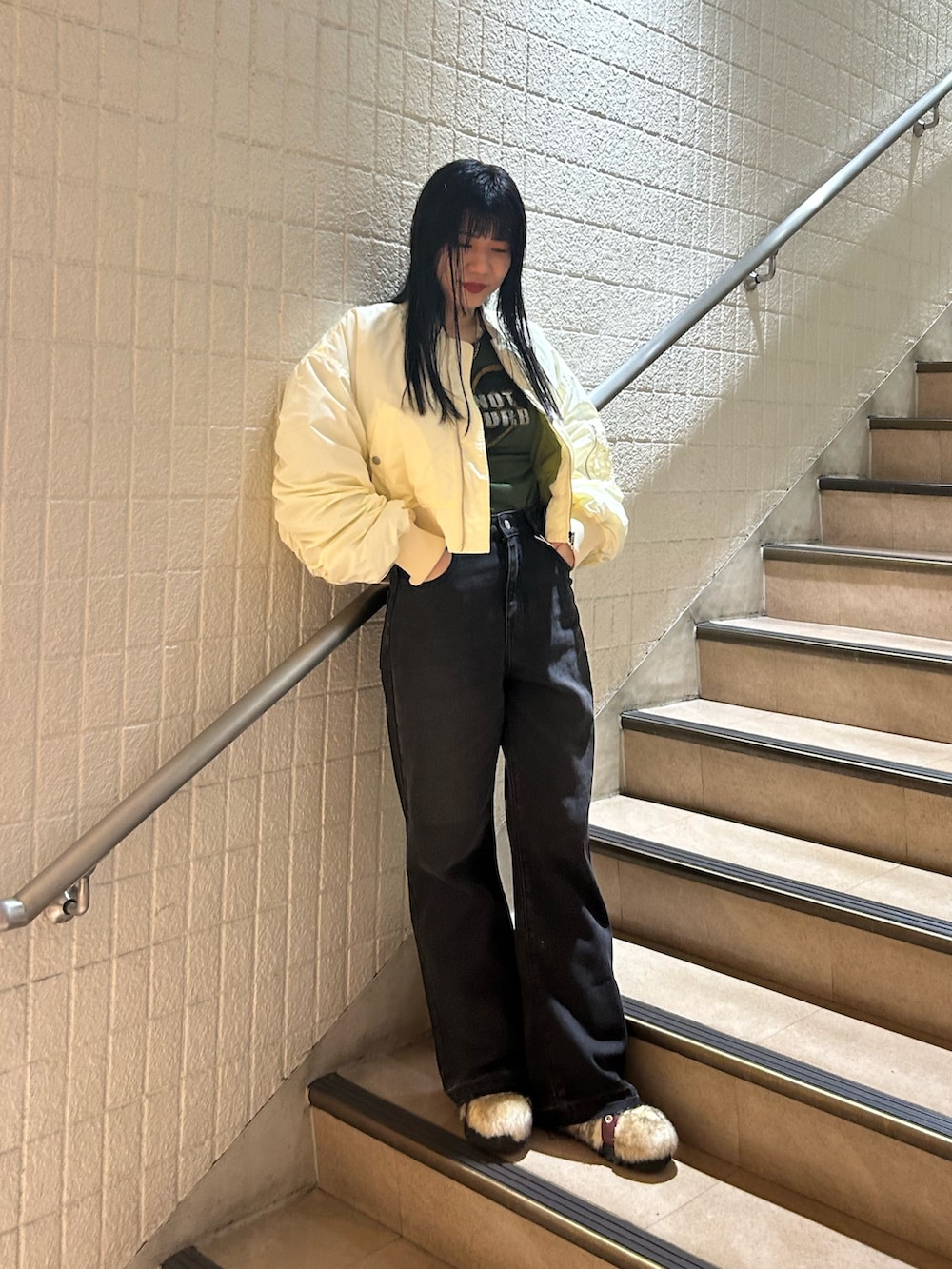 ベージュ系のブーツ、ブラック系のデニムパンツ、ホワイト系のMA-1を着用したレディースの秋コーディネートの2枚目の写真