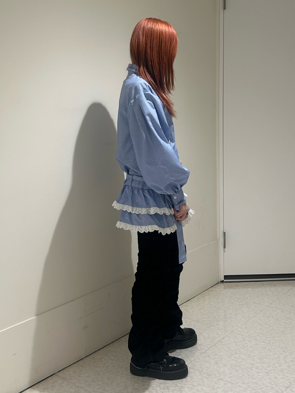 ブルー系のシャツ/ブラウス、ブラック系のデニムパンツ、ブラック系のブーツを着用したレディースの冬コーディネートの2枚目の写真