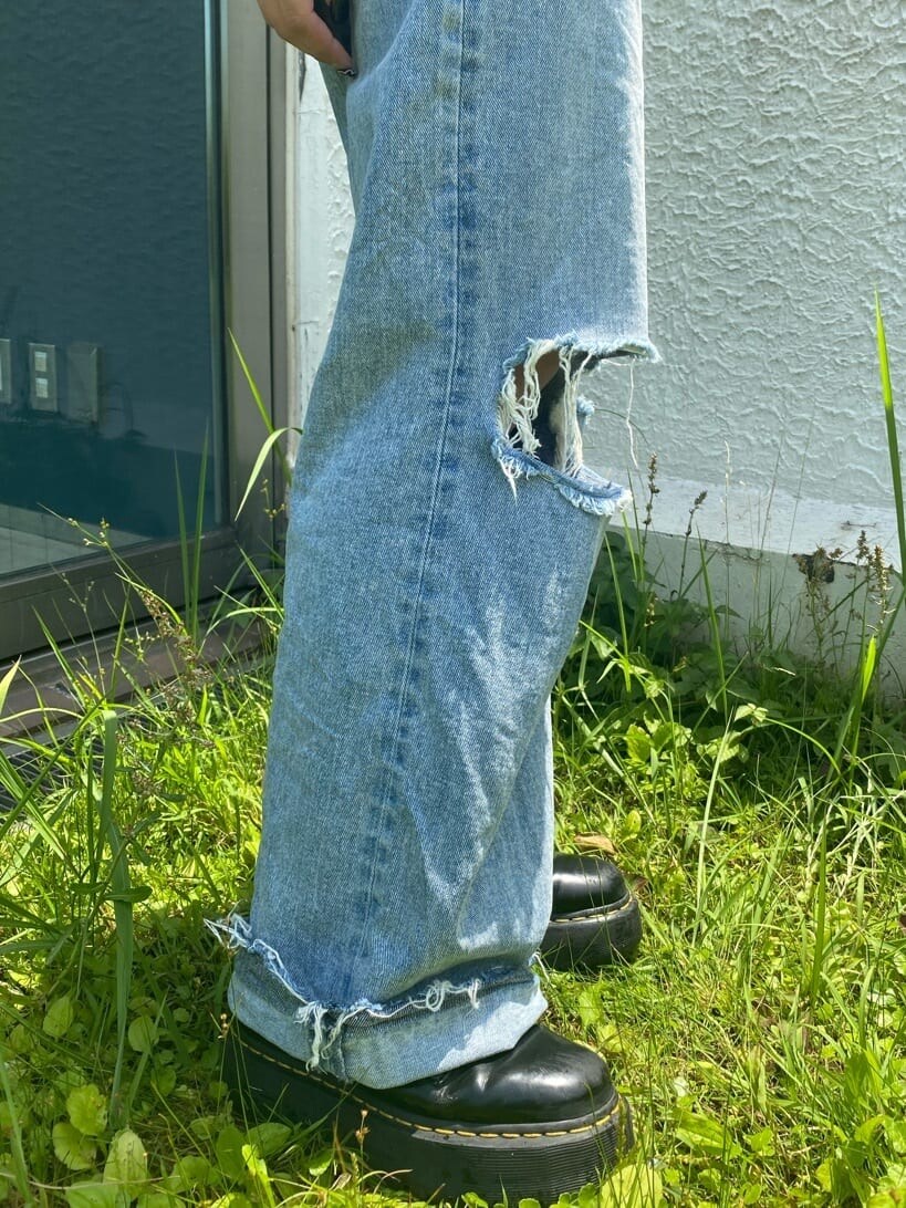 ブラック系のブーツ、ブルー系のデニムパンツ、レッド系のニット/セーターを着用したレディースの夏コーディネートの8枚目の写真