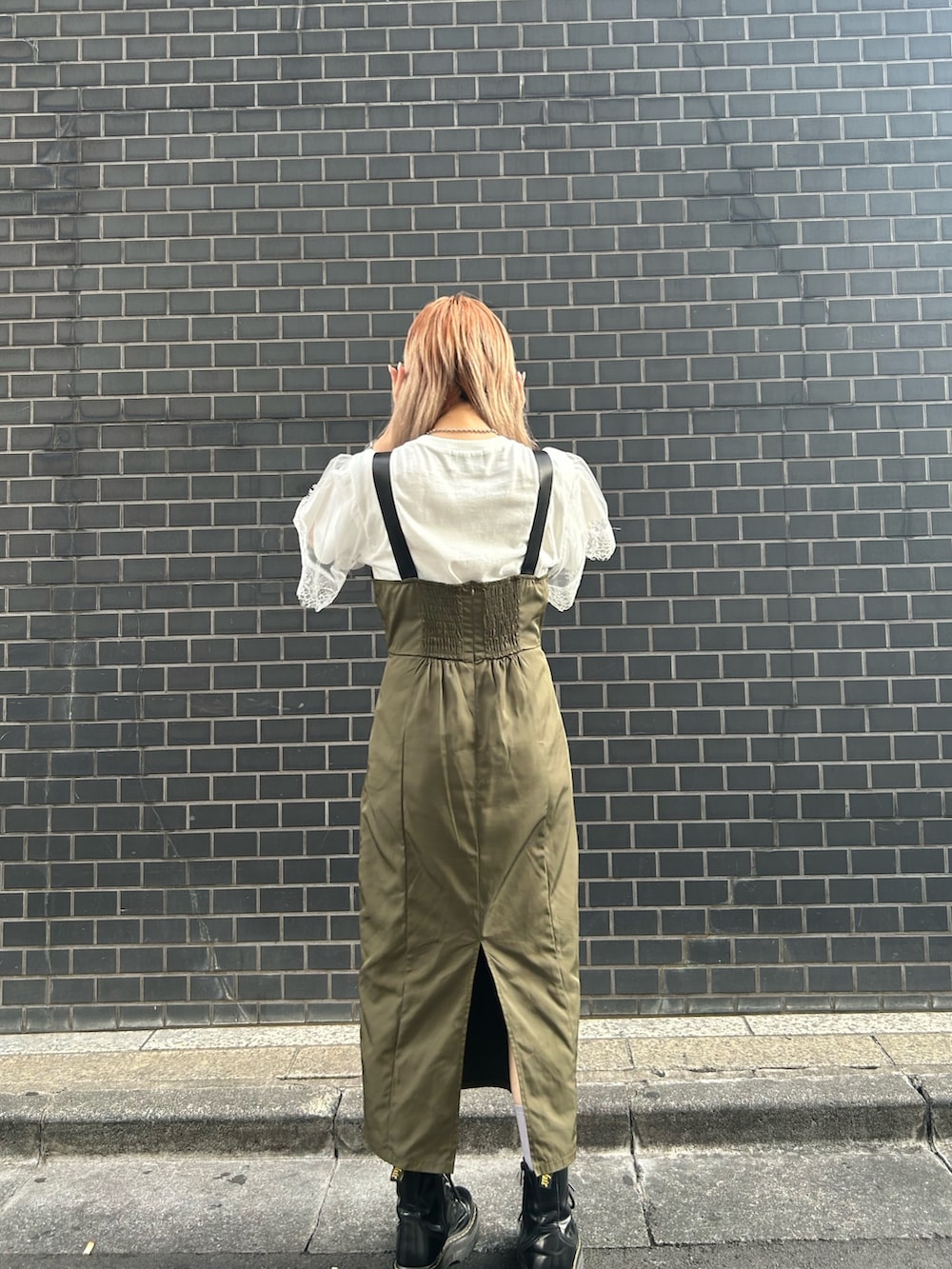 ブラック系のブーツ、グリーン系のジャンパースカート、ホワイト系のTシャツ/カットソーを着用したレディースの夏コーディネートの3枚目の写真