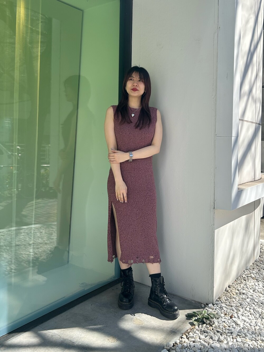 ブラック系のブーツ、ピンク系のワンピース、シルバー系のキャミソールを着用したレディースの春コーディネートの2枚目の写真