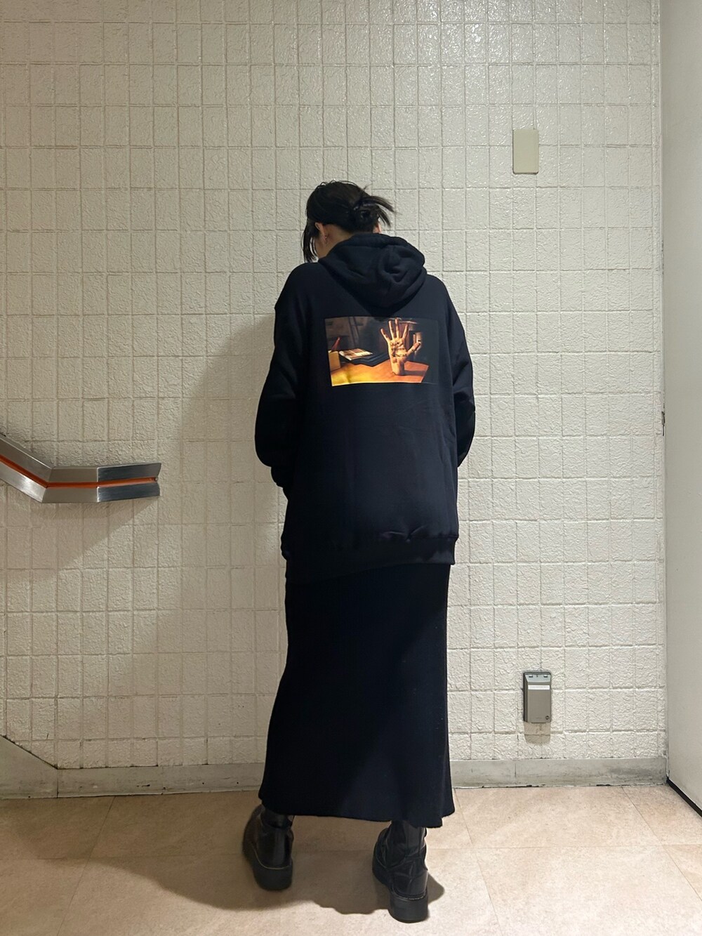 ブラック系のブーツ、ブラック系のスカート、ブラック系のパーカーを着用したレディースの秋コーディネートの4枚目の写真