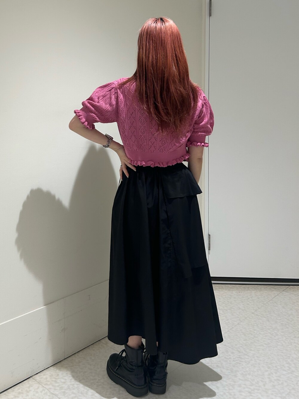 ブラック系のスカート、ブラック系のブーツ、ピンク系のカーディガン/ボレロを着用したレディースの春コーディネートの3枚目の写真