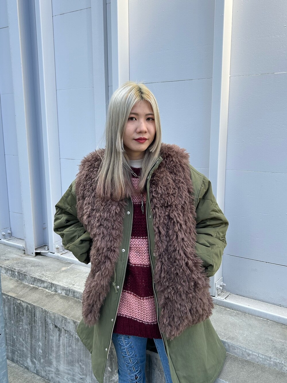 グリーン系のモッズコート、レッド系のニット/セーター、ホワイト系のTシャツ/カットソーを着用したレディースの秋コーディネートの4枚目の写真