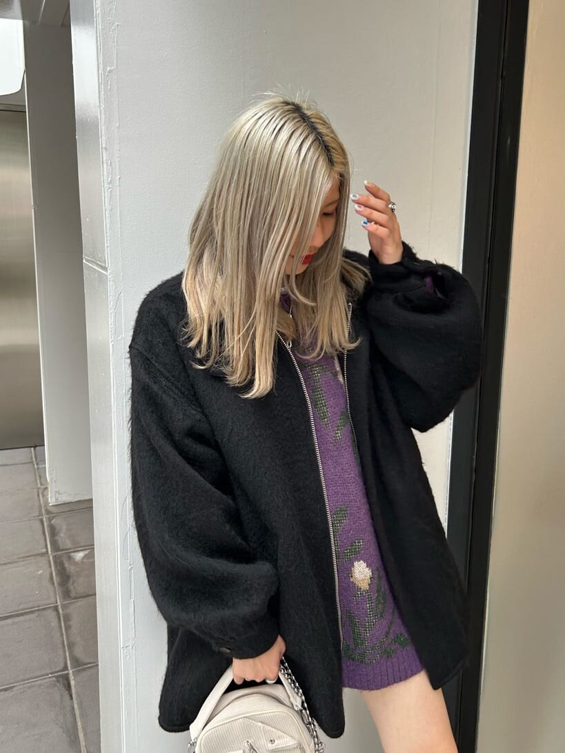 ブラック系のブーツ、ホワイト系のハンドバッグ、ブラック系のデニムパンツを着用したレディースの秋コーディネートの6枚目の写真