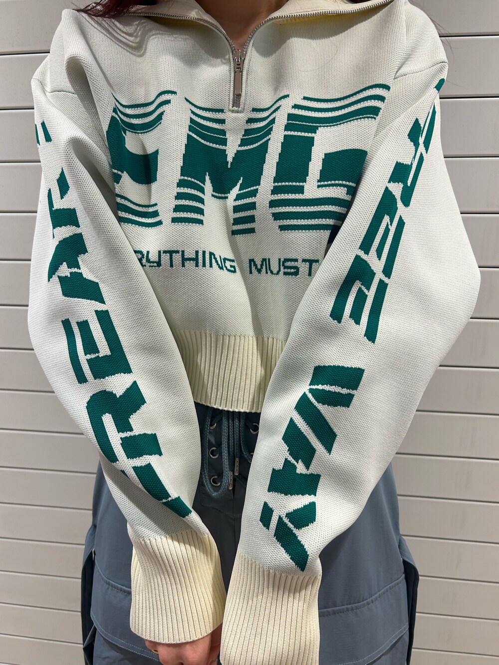 グレー系のその他パンツ、ブラック系のブーツ、ホワイト系のニット/セーターを着用したレディースの春コーディネートの5枚目の写真