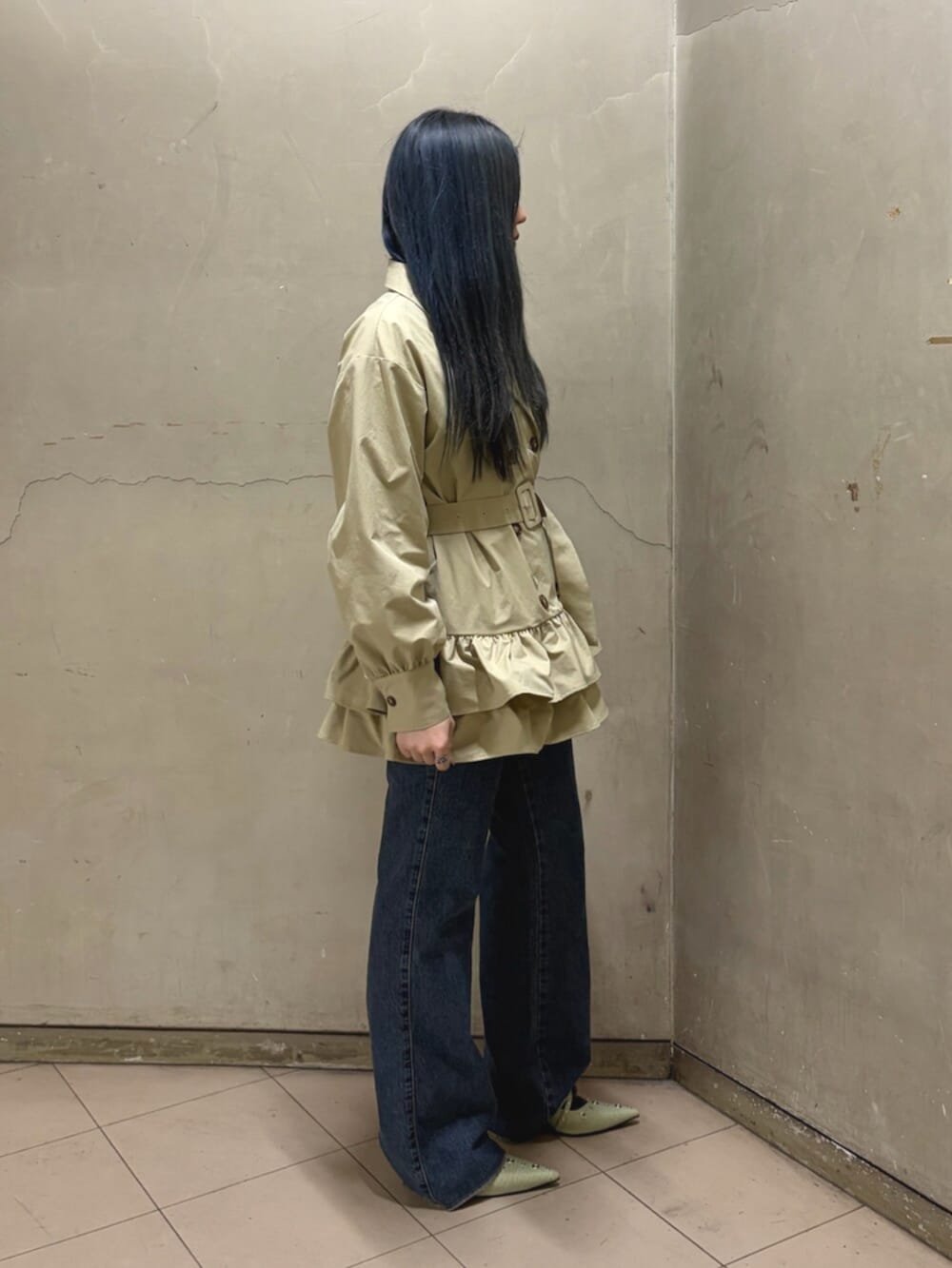 ベージュ系のワンピース、ホワイト系のTシャツ/カットソー、ブルー系のデニムパンツを着用したレディースの春コーディネートの2枚目の写真