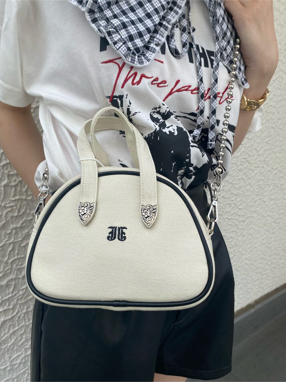 ブラック系のブーツ、ホワイト系のTシャツ/カットソー、ホワイト系のボストンバッグを着用したレディースの夏コーディネートの9枚目の写真