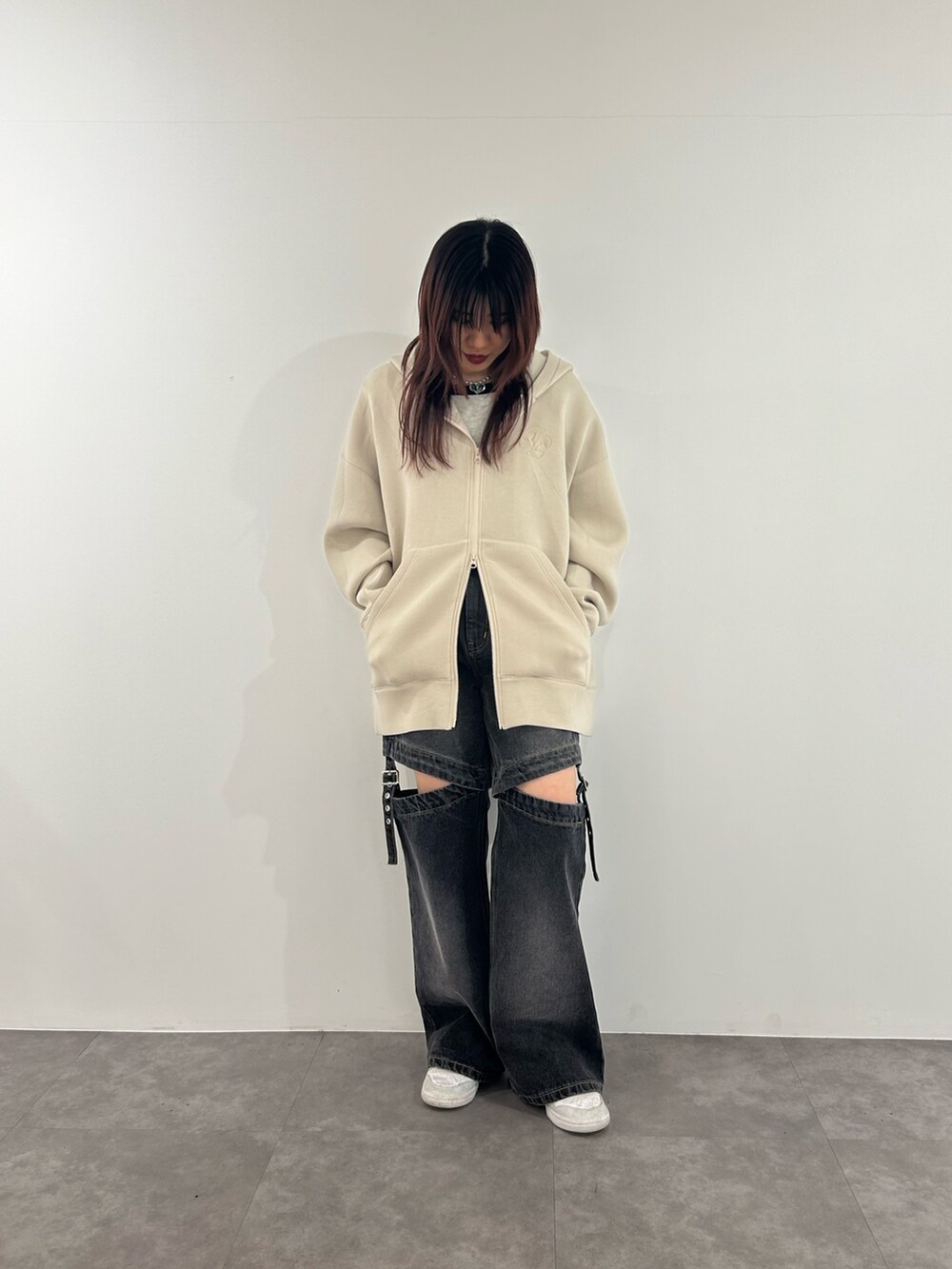 ブラック系のデニムパンツ、ホワイト系のパーカー、ホワイト系のニット/セーターを着用したレディースの春コーディネートの2枚目の写真