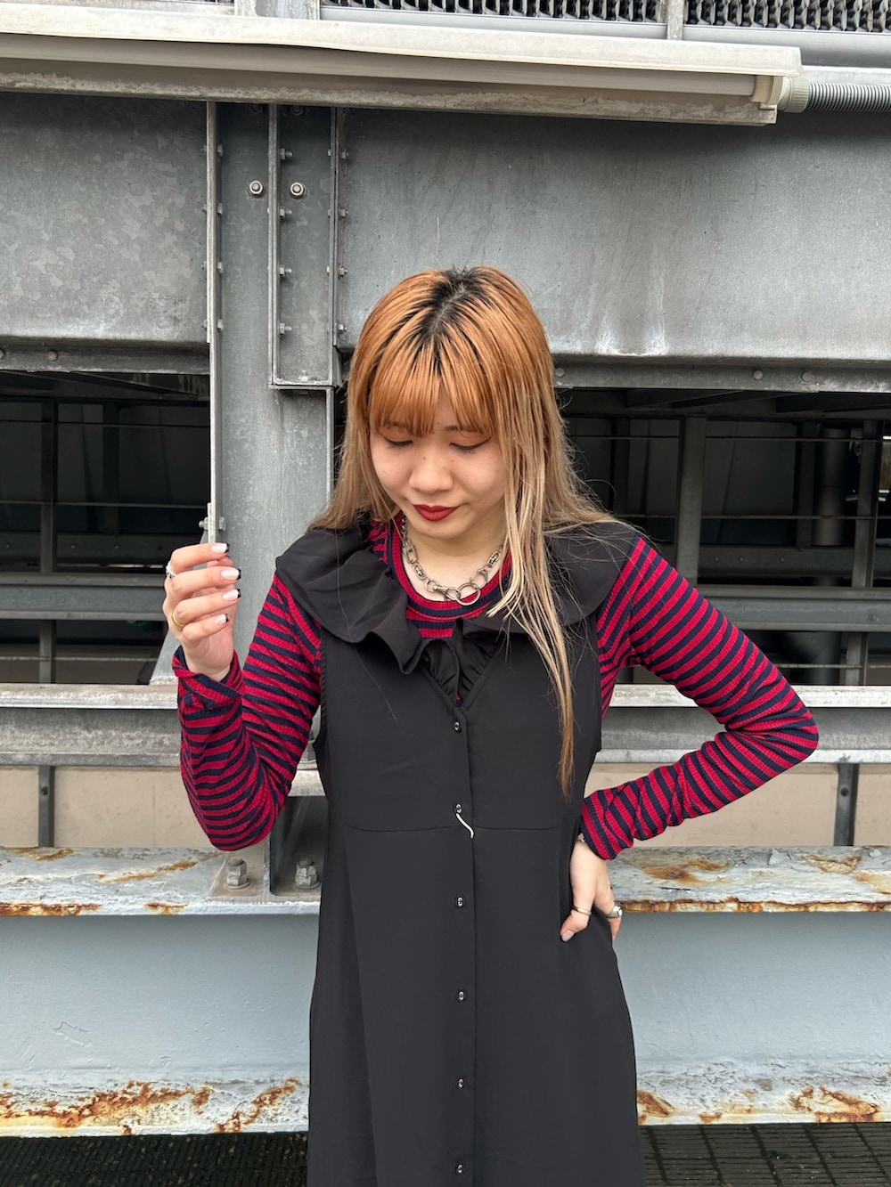 ブラック系のブーツ、ブラック系のワンピース、レッド系のTシャツ/カットソーを着用したレディースの夏コーディネートの3枚目の写真