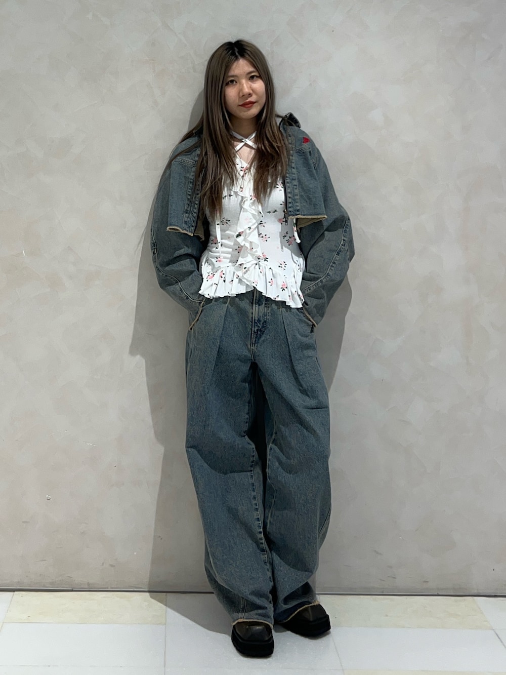 ブラック系のブーツ、ブルー系のデニムパンツ、ブルー系のデニムジャケットを着用したレディースの秋コーディネートの2枚目の写真