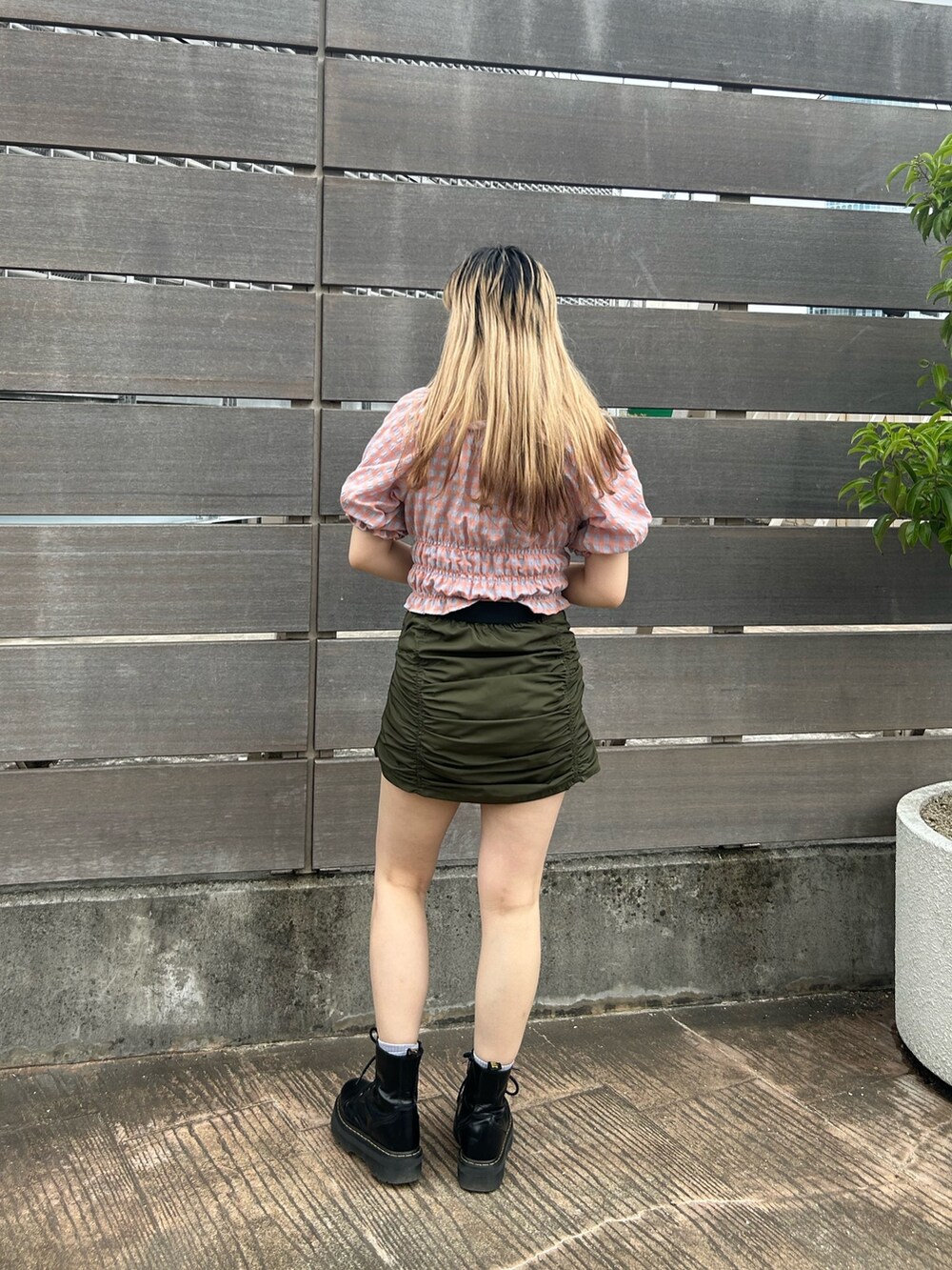 ブラック系のブーツ、オレンジ系のシャツ/ブラウス、グリーン系のスカートを着用したレディースの夏コーディネートの3枚目の写真