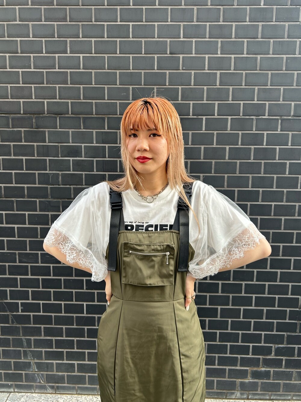ブラック系のブーツ、グリーン系のジャンパースカート、ホワイト系のTシャツ/カットソーを着用したレディースの夏コーディネートの5枚目の写真