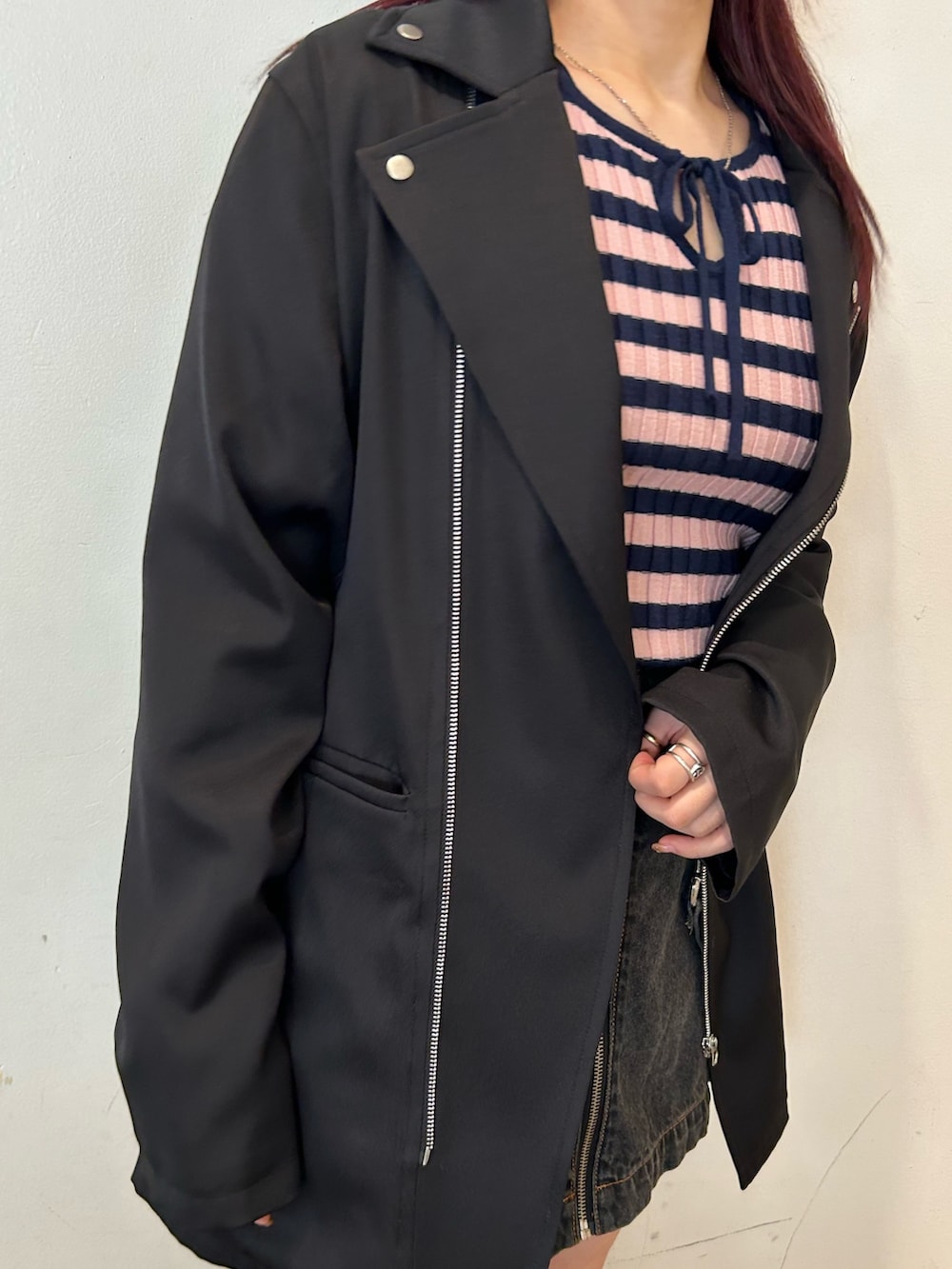 ブラック系のブーツ、ブラック系のデニムスカート、ブラック系のワンピースを着用したレディースの冬コーディネートの6枚目の写真