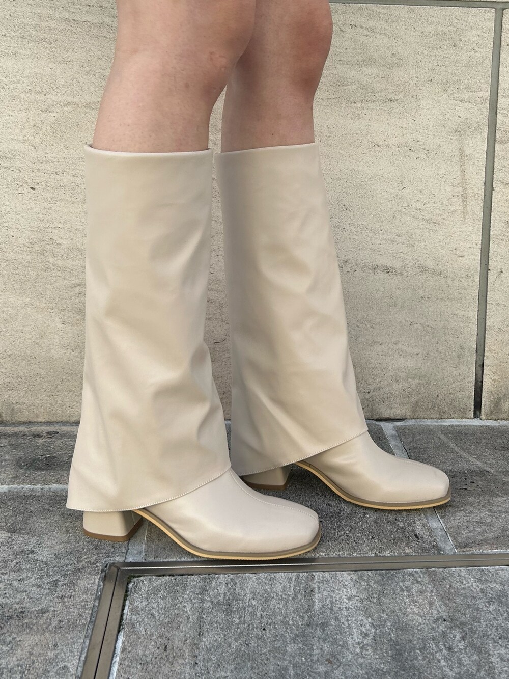 ブラック系のデニムパンツ、ホワイト系のブーツ、ブラック系のニット/セーターを着用したレディースの冬コーディネートの7枚目の写真