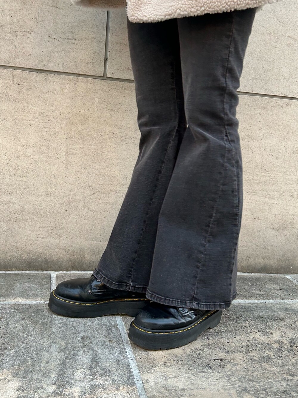 ブラック系のムートンコート、ブラック系のデニムパンツ、ブラック系のブーツを着用したレディースの秋コーディネートの8枚目の写真
