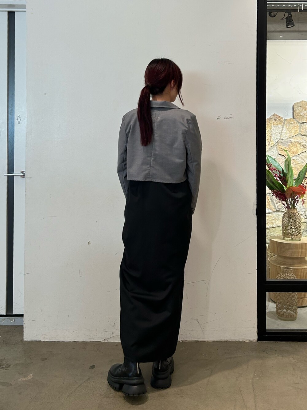 ブラック系のブーツ、ブラック系のワンピース、ブルー系のTシャツ/カットソーを着用したレディースの春コーディネートの3枚目の写真