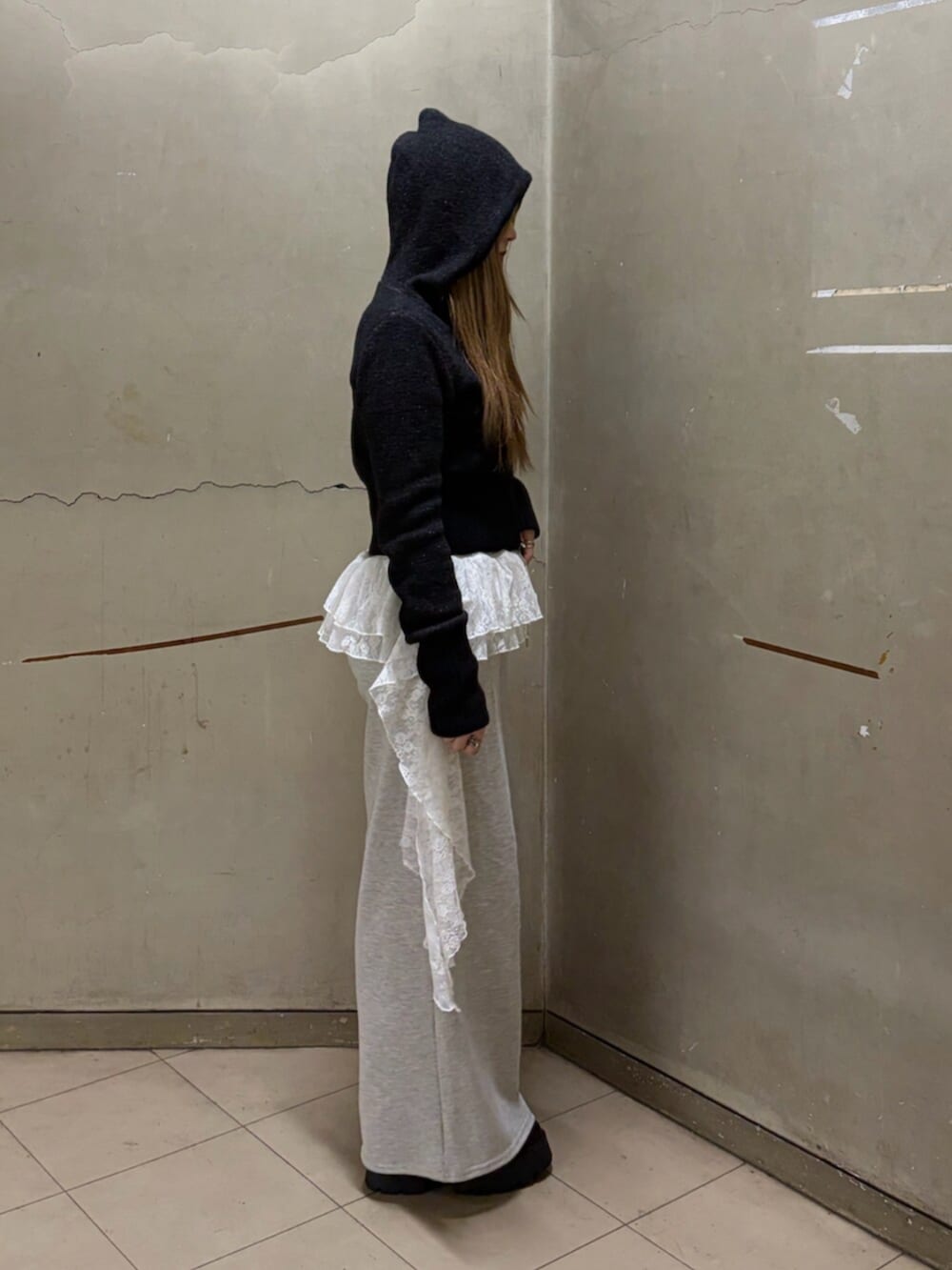 ブラック系のパーカー、グレー系のスウェットパンツ、ブラック系のローファーを着用したレディースの冬コーディネートの2枚目の写真