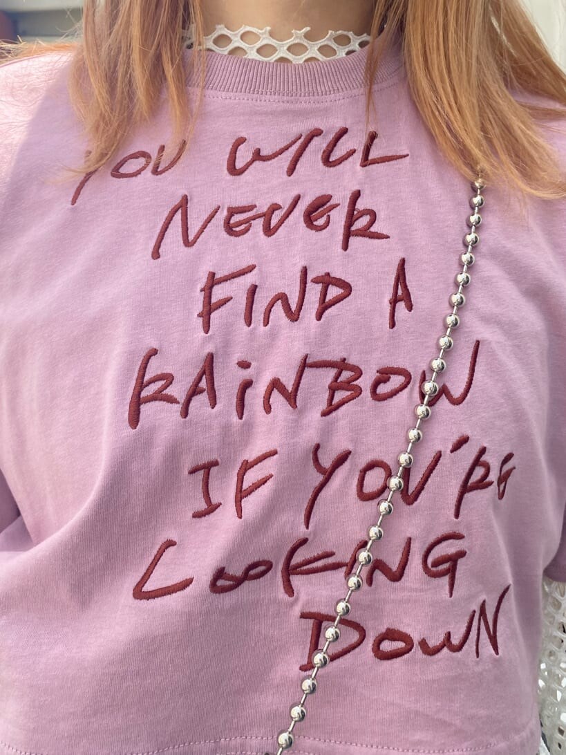 ブラック系のデニムパンツ、ホワイト系のTシャツ/カットソー、ブラック系のブーツを着用したレディースの夏コーディネートの6枚目の写真