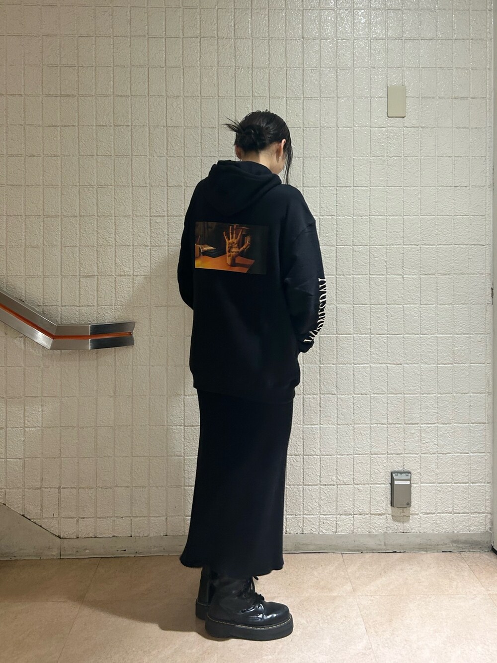 ブラック系のブーツ、ブラック系のスカート、ブラック系のパーカーを着用したレディースの秋コーディネートの3枚目の写真