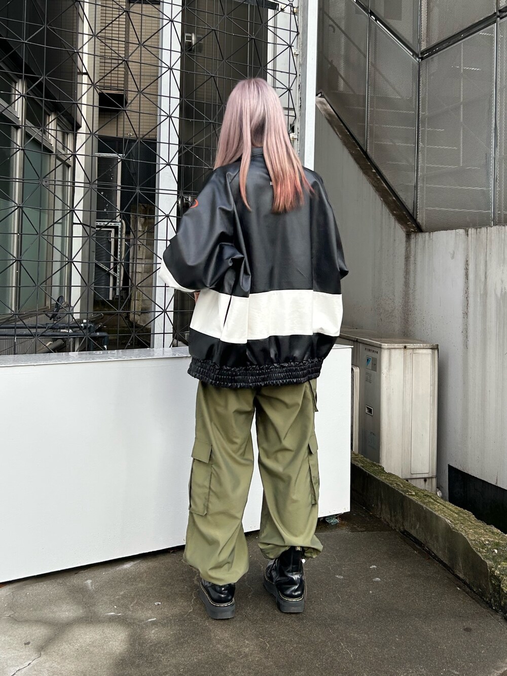 ブラック系のブーツ、ブラック系のブルゾン、ピンク系のTシャツ/カットソーを着用したレディースの冬コーディネートの2枚目の写真