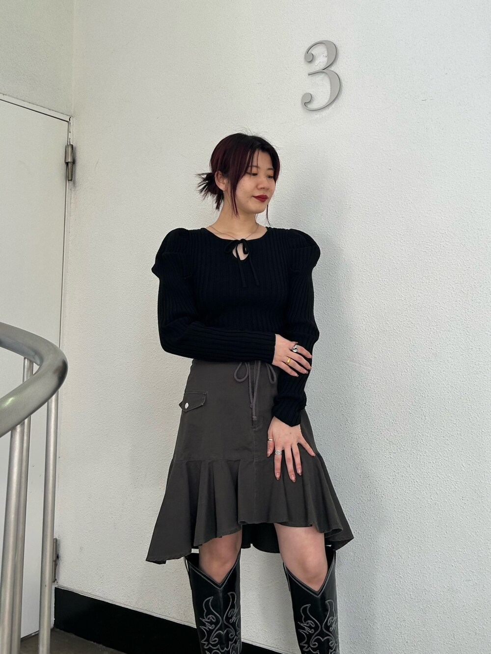 ブラック系のブーツ、ブラック系のスカート、ブラック系のニット/セーターを着用したレディースの冬コーディネートの5枚目の写真