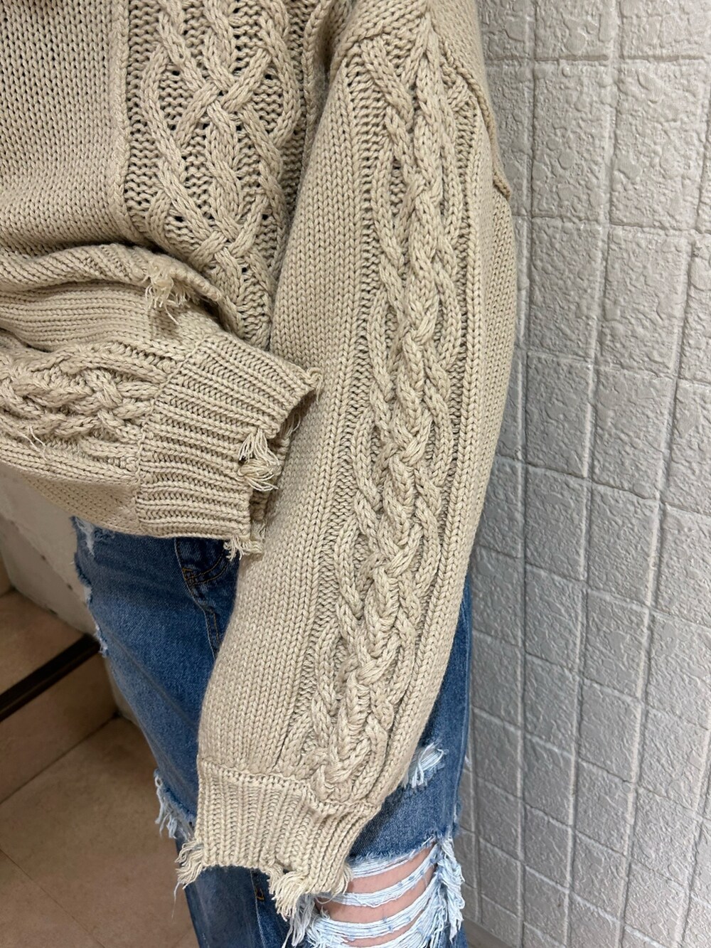 ブラック系のブーツ、ブルー系のデニムスカート、ホワイト系のニット/セーターを着用したレディースの冬コーディネートの7枚目の写真