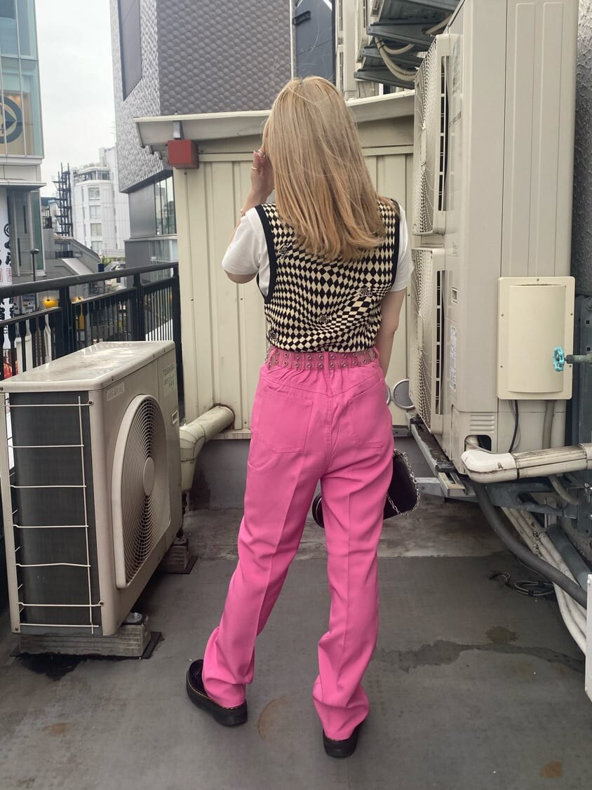 ブラック系のニット/セーター、ホワイト系のTシャツ/カットソー、ピンク系のスラックスを着用したレディースの夏コーディネートの3枚目の写真