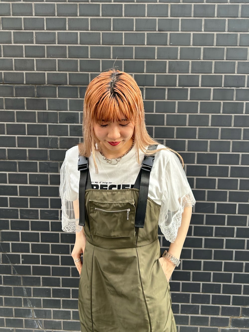 ブラック系のブーツ、グリーン系のジャンパースカート、ホワイト系のTシャツ/カットソーを着用したレディースの夏コーディネートの4枚目の写真