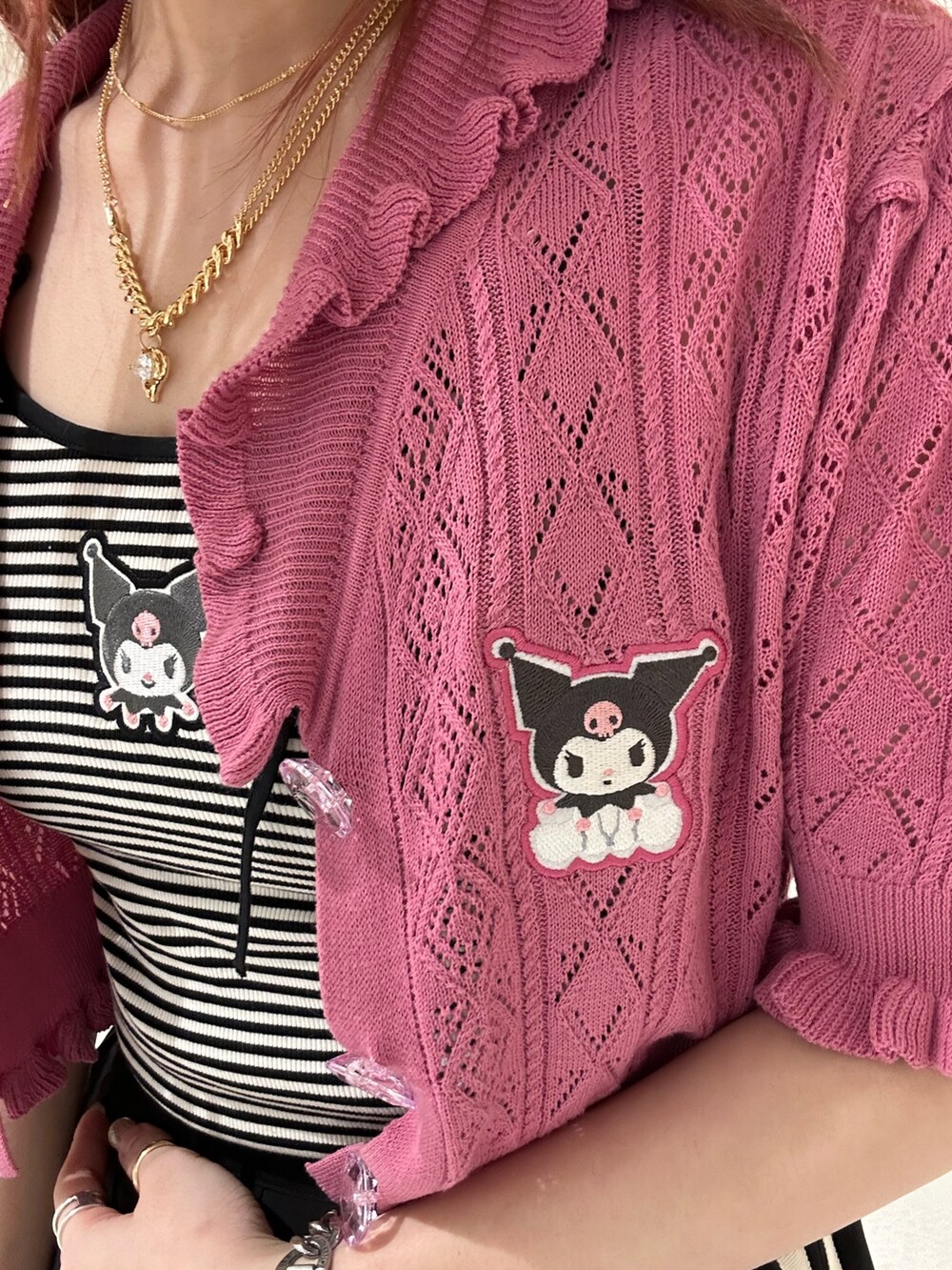 ブラック系のスカート、ブラック系のブーツ、ピンク系のカーディガン/ボレロを着用したレディースの春コーディネートの5枚目の写真