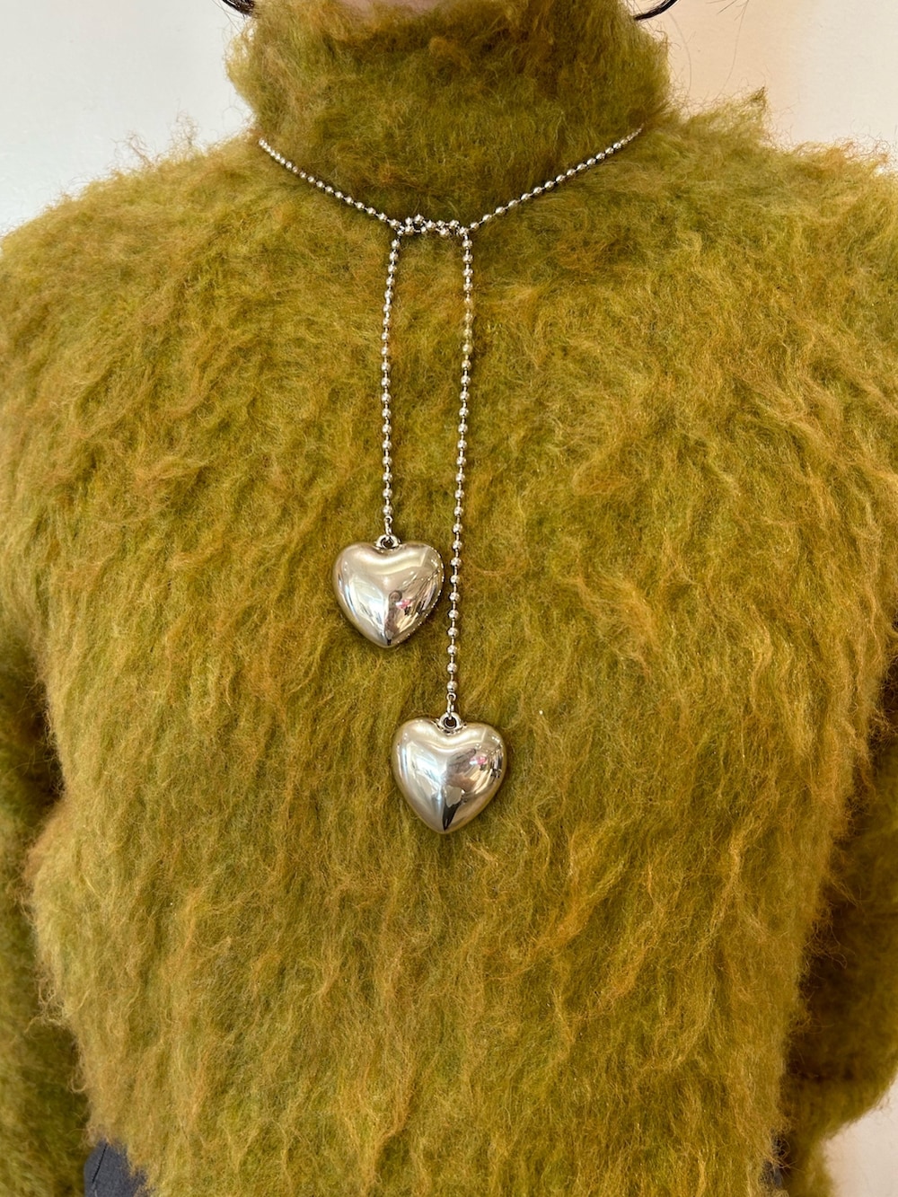 ブラック系のブーツ、イエロー系のニット/セーター、グレー系のその他パンツを着用したレディースの秋コーディネートの4枚目の写真