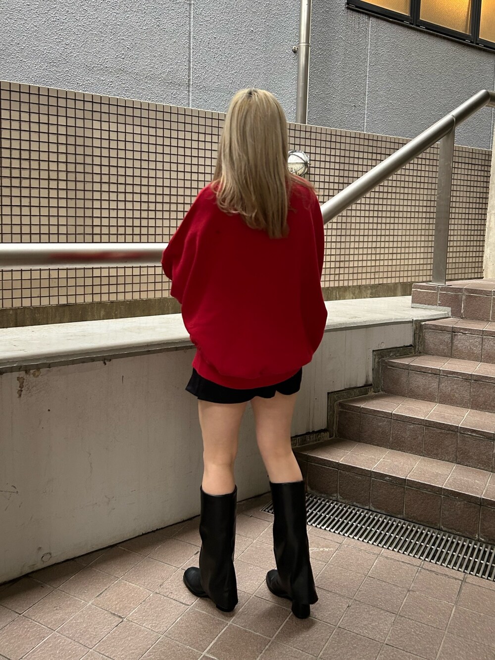 レッド系のスウェット、ブラック系のその他パンツ、レッド系のニット/セーターを着用したレディースの冬コーディネートの2枚目の写真