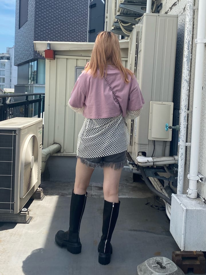 ブラック系のデニムパンツ、ホワイト系のTシャツ/カットソー、ブラック系のブーツを着用したレディースの夏コーディネートの3枚目の写真