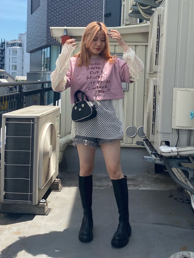 ブラック系のデニムパンツ、ホワイト系のTシャツ/カットソー、ブラック系のブーツを着用したレディースの夏コーディネートの2枚目の写真