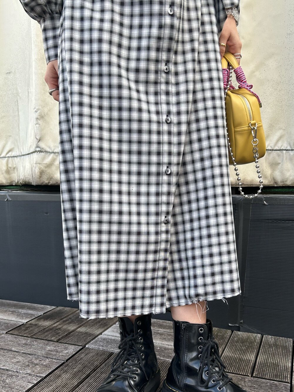 ブラック系のブーツ、イエロー系のショルダーバッグ、ブラック系のワンピースを着用したレディースの冬コーディネートの5枚目の写真