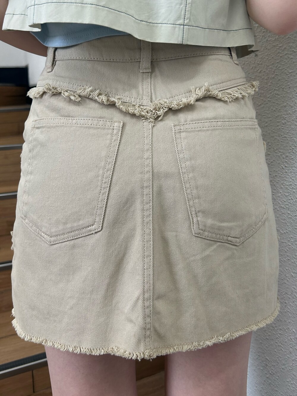 ベージュ系のスカート、ブラック系のブーツ、ブルー系のTシャツ/カットソーを着用したレディースの夏コーディネートの6枚目の写真