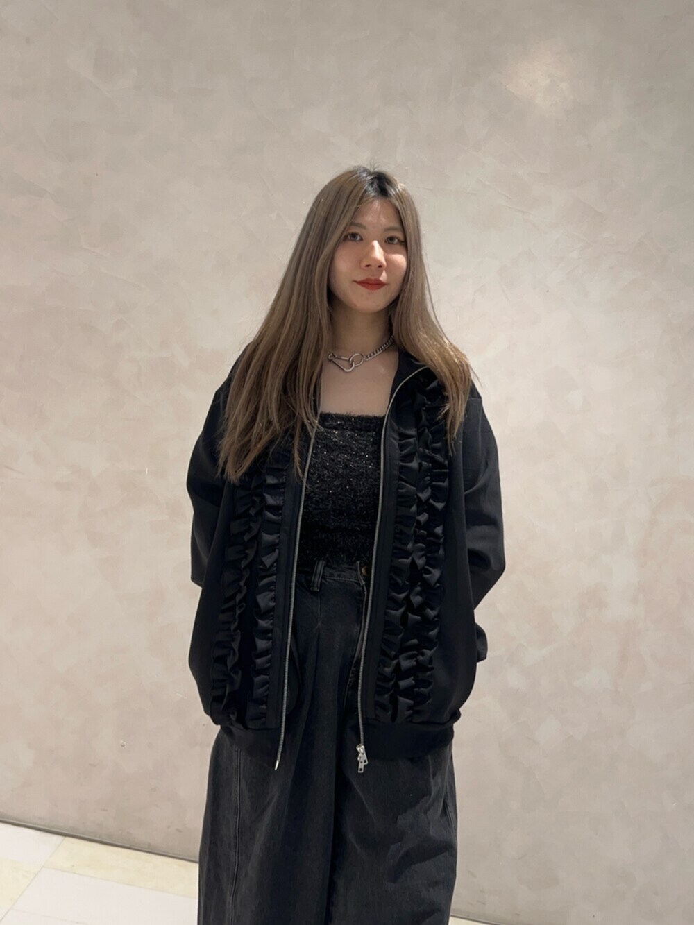 ブラック系のパンプス、ブラック系のデニムパンツ、ブラック系のアンサンブルを着用したレディースの秋コーディネートの4枚目の写真