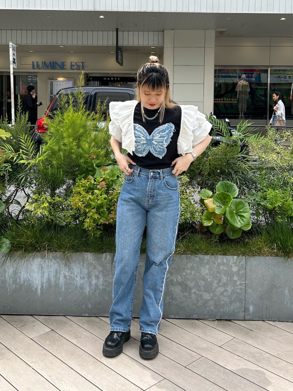 ブラック系のブーツ、ブラック系のTシャツ/カットソー、ホワイト系のシャツ/ブラウスを着用したレディースの春コーディネートの2枚目の写真