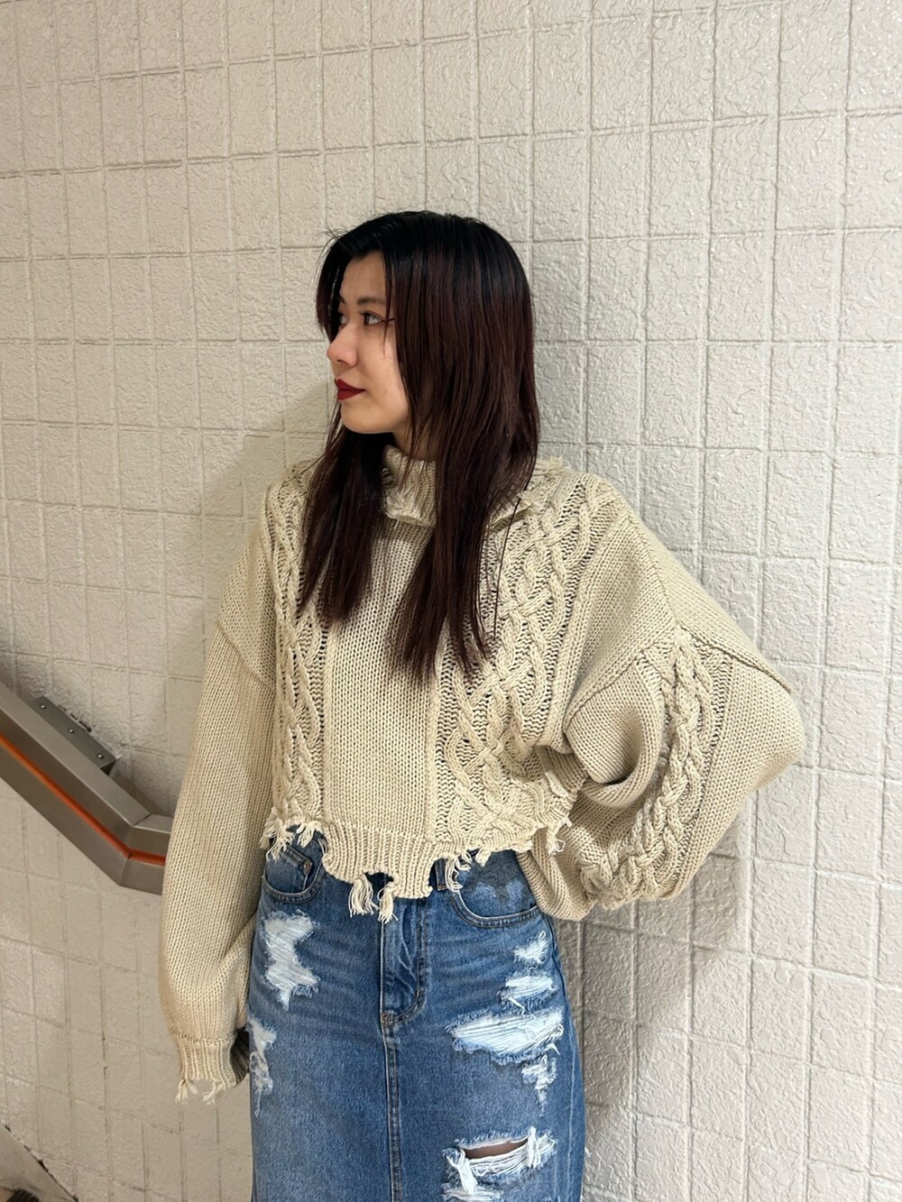 ブラック系のブーツ、ブルー系のデニムスカート、ホワイト系のニット/セーターを着用したレディースの冬コーディネートの5枚目の写真