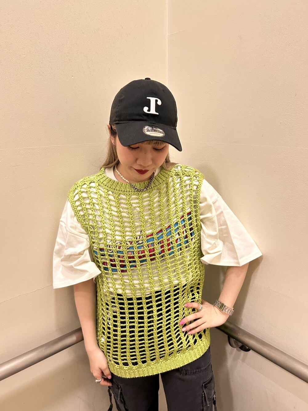 ホワイト系のTシャツ/カットソー、ブラック系のカーゴパンツ、グリーン系のベストを着用したレディースの春コーディネートの4枚目の写真