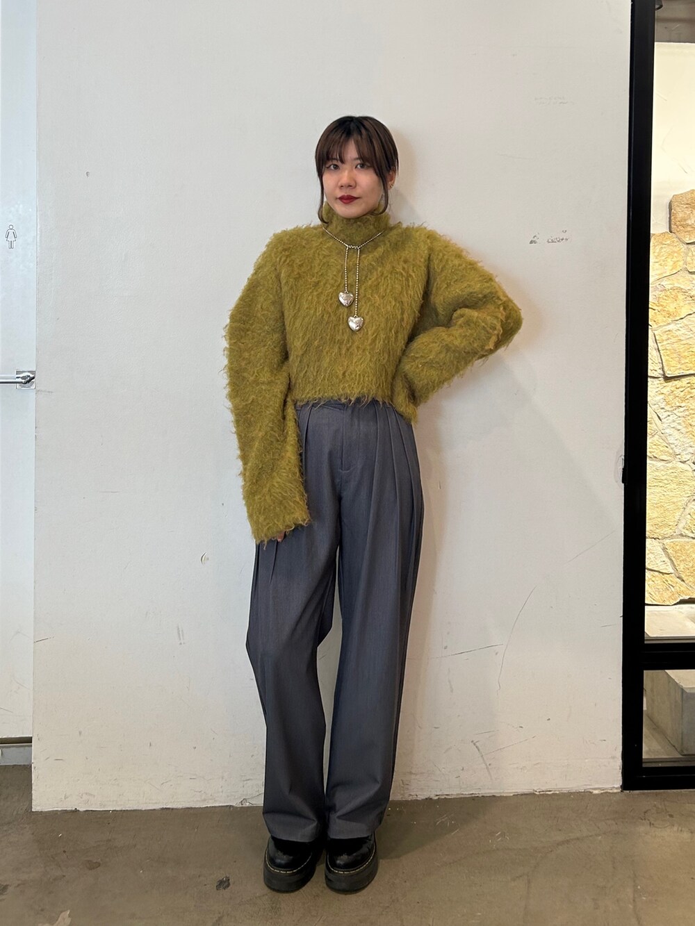 ブラック系のブーツ、イエロー系のニット/セーター、グレー系のその他パンツを着用したレディースの秋コーディネートの2枚目の写真