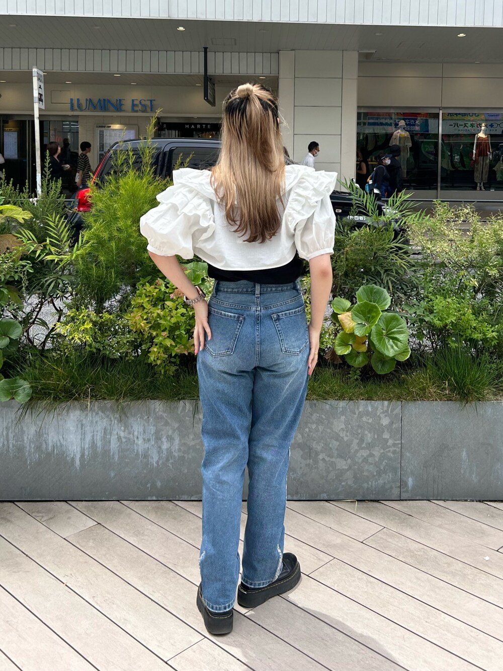 ブラック系のブーツ、ブラック系のTシャツ/カットソー、ホワイト系のシャツ/ブラウスを着用したレディースの春コーディネートの3枚目の写真