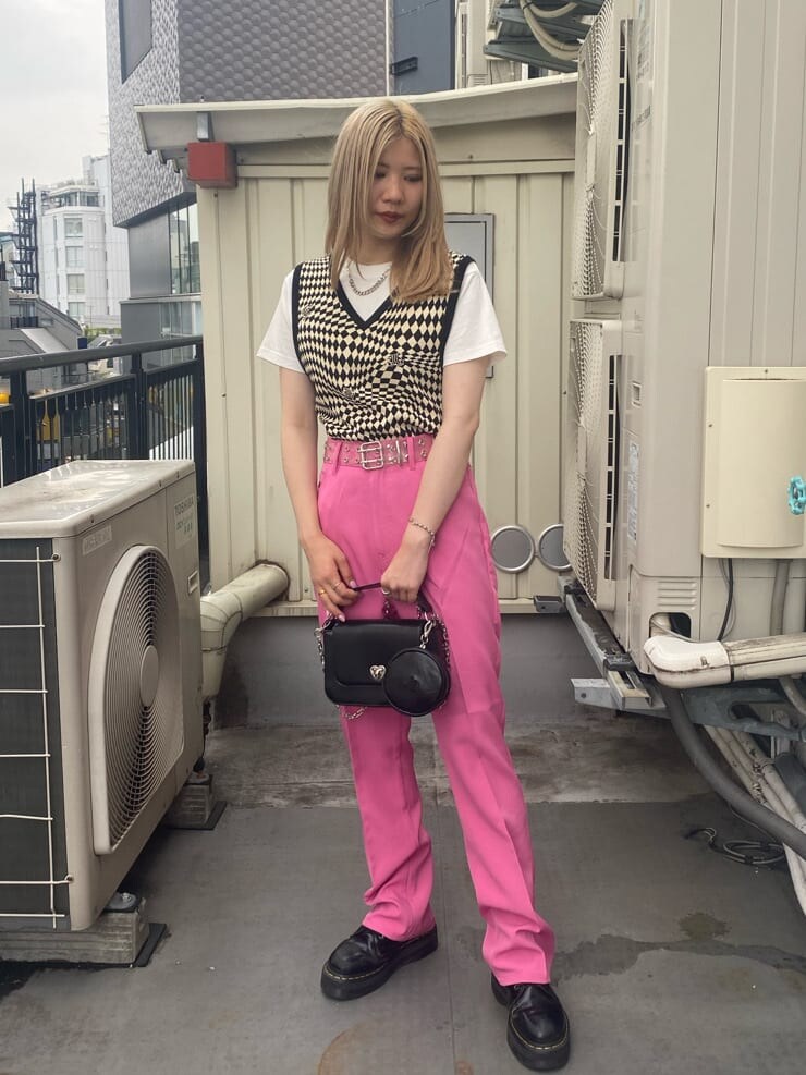 ブラック系のニット/セーター、ホワイト系のTシャツ/カットソー、ピンク系のスラックスを着用したレディースの夏コーディネートの2枚目の写真