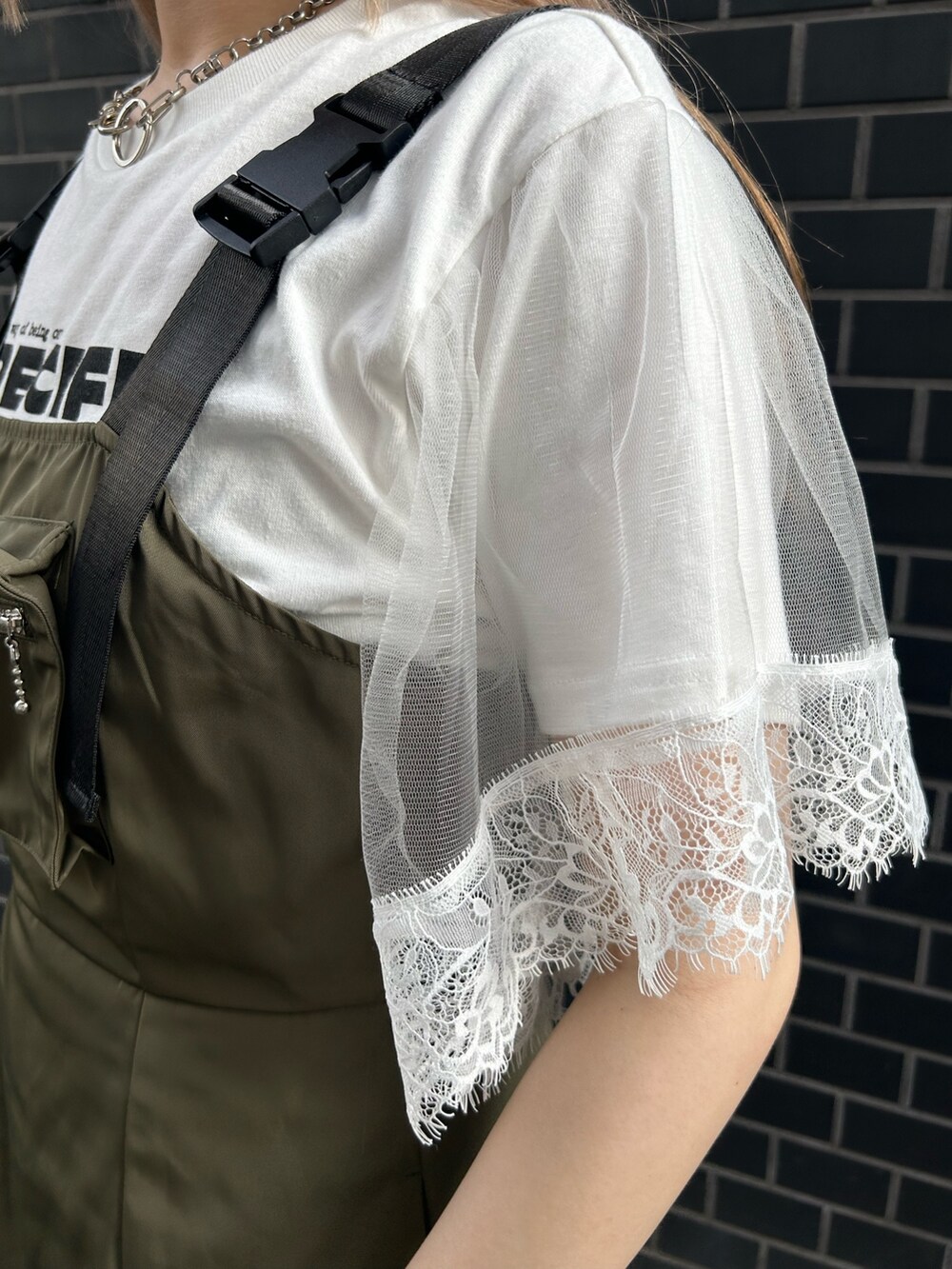 ブラック系のブーツ、グリーン系のジャンパースカート、ホワイト系のTシャツ/カットソーを着用したレディースの夏コーディネートの7枚目の写真