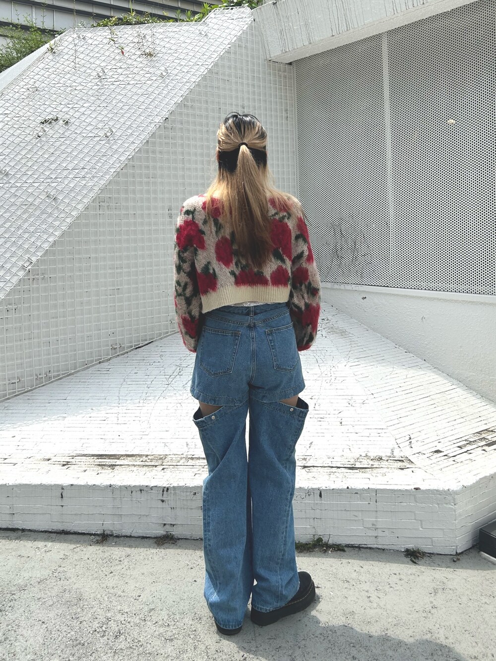 ブラック系のブーツ、ホワイト系のTシャツ/カットソー、ブルー系のデニムパンツを着用したレディースの夏コーディネートの2枚目の写真