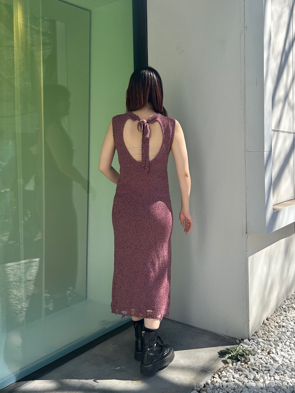 ブラック系のブーツ、ピンク系のワンピース、シルバー系のキャミソールを着用したレディースの春コーディネートの3枚目の写真